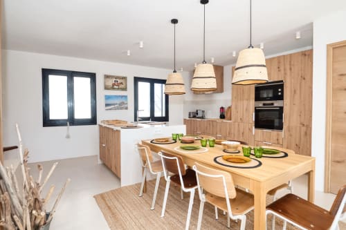 Modern kitchen-dining area at Finques Garcia Enrich, Palafrugell, with wooden furnishings and pendant lighting