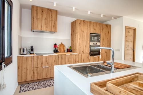 Modern kitchen with wooden cabinets and white countertops at Finques Garcia Enrich hotel in Palafrugell