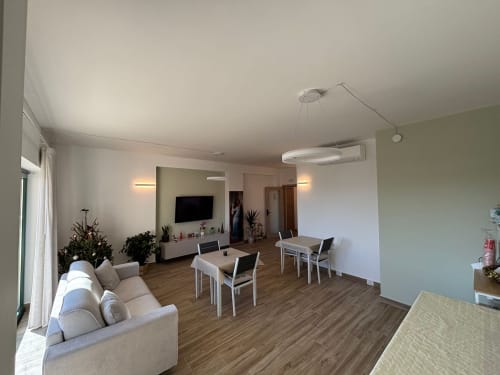 Zona living moderna a pianta aperta presso La Dimora Di Ipno a Vallata con tavolo da pranzo, comodo divano, TV e vista sul giardino