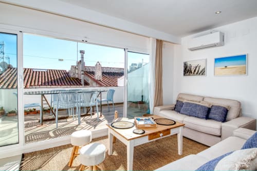 Bright sea-view cottage in Palafrugell with terrace, sofa, dining table, and modern amenities overlooking coastal rooftops