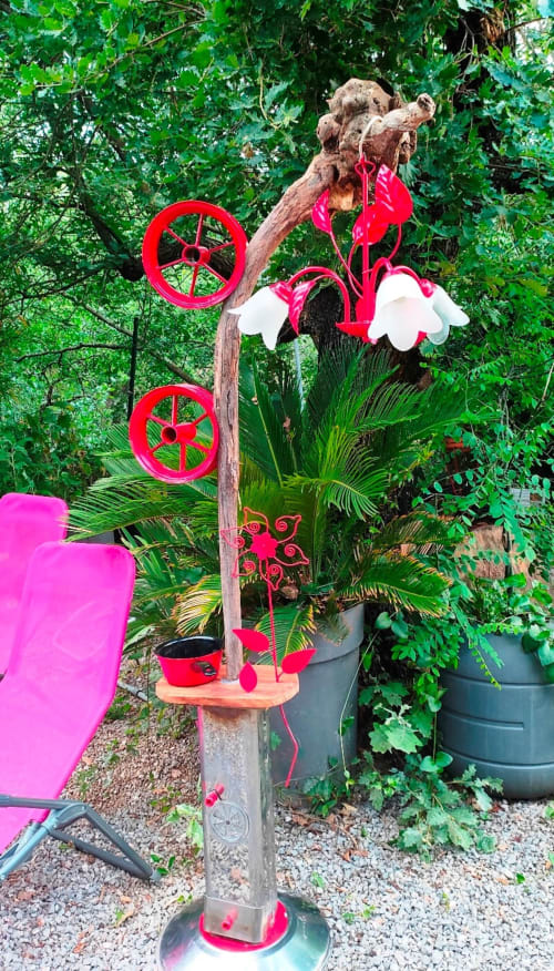 Lampadaire artistique détourné : un tronc, des roues, un luminaire et une casserole transformés en une création unique. Œuvre de recyclage signée Florent Arnaud, visible au Portel des Arnaud, chambres d'hôtes dans les Cévennes, sud de la France. Séjour nature et détente, hotel
