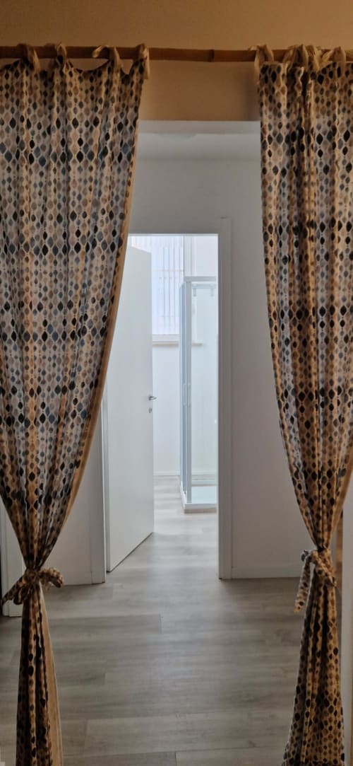Patterned curtains frame a hallway entrance at Lamar Suites Seafront Apartments in Misano Adriatico