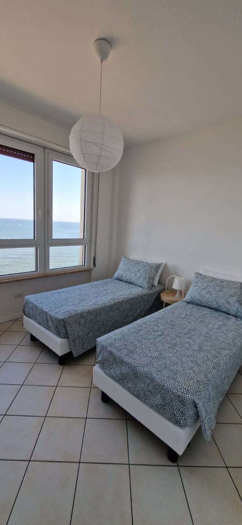 Twin bedroom with sea view at Lamar Suites Seafront Apartments, Misano Adriatico, featuring beds and ocean windows