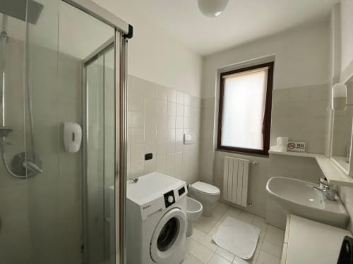 Bagno moderno dell'Appartamento Roma 1 presso THE V Collection, Turate, con lavatrice, wc, lavandino e box doccia