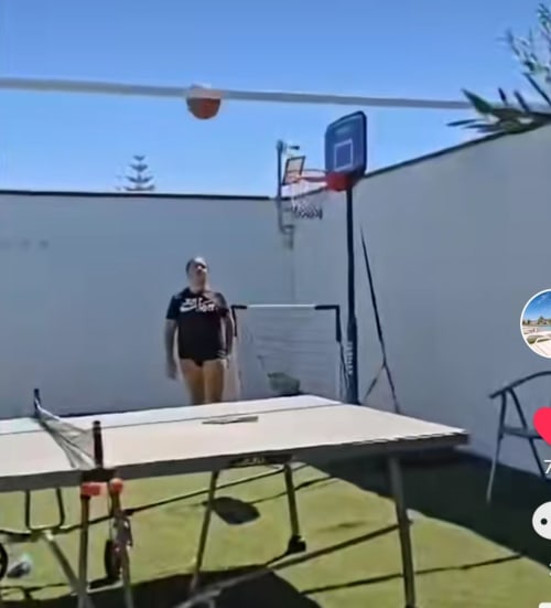 Guest playing basketball in sunny courtyard at Bungalow Buda Beach, Chipiona with table tennis and outdoor amenities