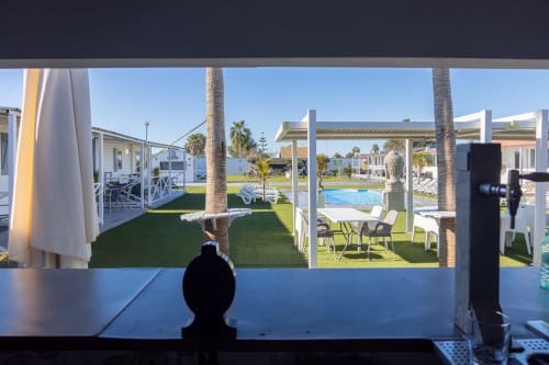 View from Bungalow D at Buda Beach hotel in Chipiona, Spain, overlooking manicured gardens, palm trees, and swimming pool