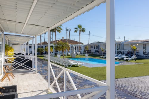 Bungalow Buda Beach terrace overlooking pool and garden in Chipiona, Spain
