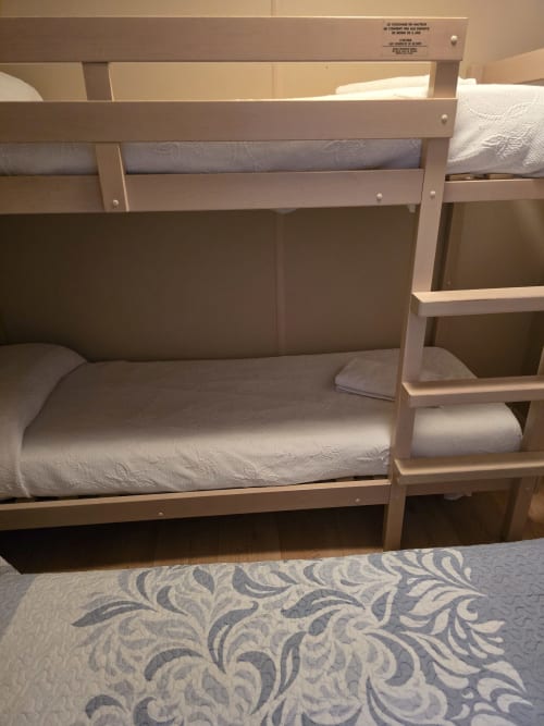 Bungalow buda beach bunk beds with white linens and storage shelves in Chipiona apartment