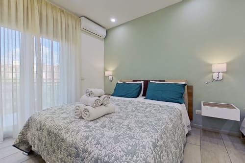 Luminosa Camera Superior al Museo19 Naples B&B con letto queen, cuscini turchesi, balcone con vista sulla città, aria condizionata e design moderno