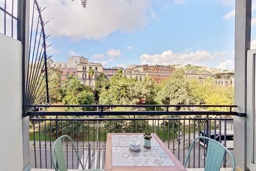 Vista dal balcone della Camera Superior presso Museo19 Napoli, affacciata su edifici cittadini, alberi verdi e cielo blu