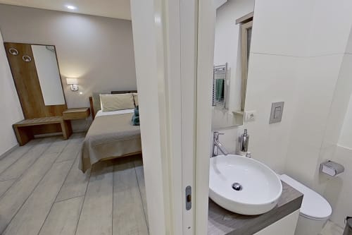 Habitación estándar en Museo19 Naples B&B con cama, escritorio y baño en suite con lavamanos redondo