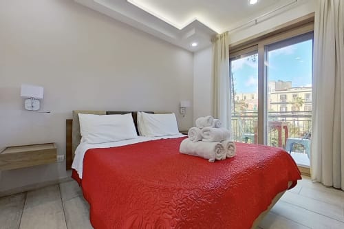 Luminosa habitación doble en Museo19 Nápoles con colcha roja, balcón con vista a la ciudad, comodidades modernas y ropa de cama blanca