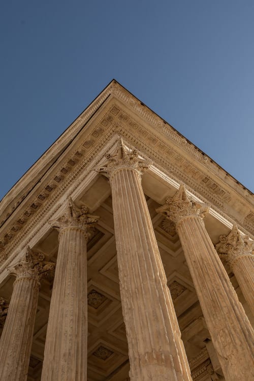 Classical Corinthian columns and ornate stonework at Le Prieuré Notre-Dame, Montfrin, France