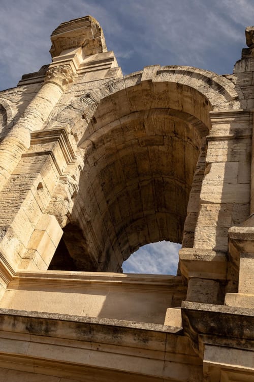 Historic stone archway at Le Prieuré Notre-Dame in Montfrin, France, featuring ancient arched doorway and weathered masonry