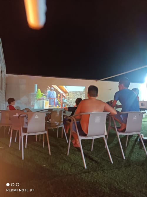 Huéspedes disfrutando de cine al aire libre en Bungalow Buda Beach en Chipiona bajo un cielo estrellado