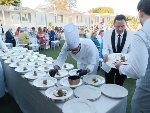 Chef presentando platos gourmet en evento de jardín al aire libre, Bungalow Buda Beach Chipiona