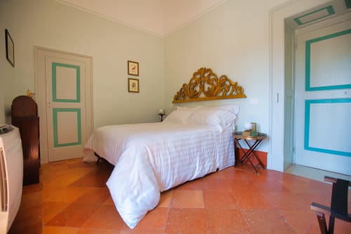 Camera da letto spaziosa a Villa Ceci ad Andria con biancheria bianca, testata in oro decorato, pavimento in cotto e