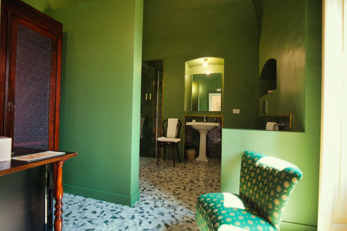 Sala d'attesa della Clinica Famiglia Villa Ceci ad Andria con pareti verde brillante, arredi vintage e balcone con vista giardino