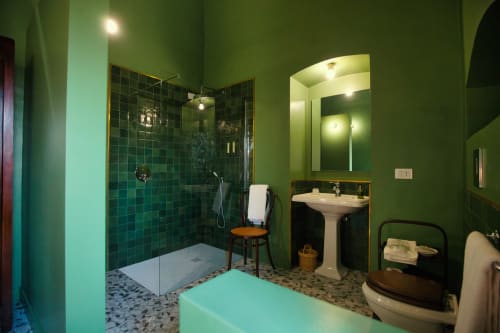 Bagno luminoso verde brillante con doccia in piastrelle verde scuro, lavabo su colonna e dettagli turchesi a Villa Ceci ad Andria