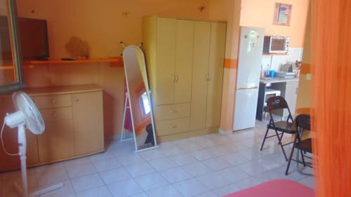 Chambre lumineuse à Caribgites, Sainte-Anne avec armoire en bois, ventilateur, miroir et kitchenette avec réfrigérateur