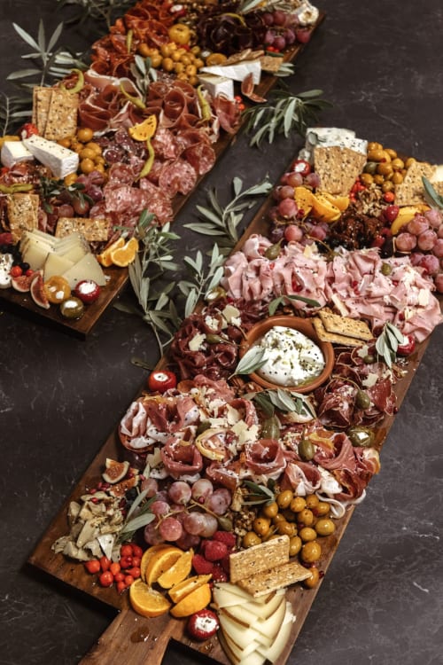 Élégants plateaux de charcuterie à la Baccara Lodge avec charcuteries, fromages, fruits et crackers sur bois foncé à Arengosse.