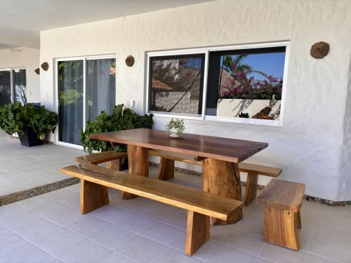 Mesa de madera con bancos en la terraza de Casa Calilla en Puerto Escondido, con vistas al jardín y al mar