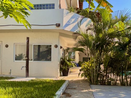 Exterior de la casa Calilla en Puerto Escondido con palmeras, área de patio y entrada privada