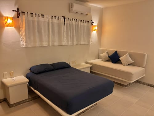 Habitación moderna en la cabaña Calilla & Tsuki en Puerto Escondido con dos camas, aire acondicionado e iluminación ambiental.