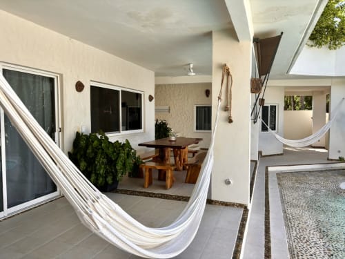 Patio de cabaña costera con hamacas, mesa de comedor y espacio de vida al aire libre en Casa Calilla, Puerto Escondido