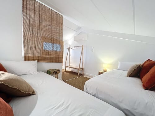 Habitación luminosa de la vivienda vacacional Estartit con dos camas individuales, persianas de madera, comodidades modernas y vistas a la piscina