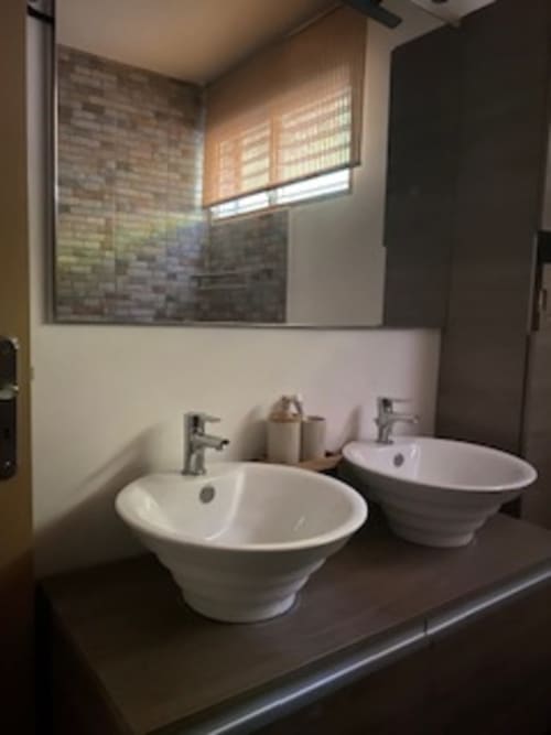 Grande salle de bain de bain lumineuse et moderne, avec deux vasques et douche italienne. Situé à l'entrée de l'escalier.