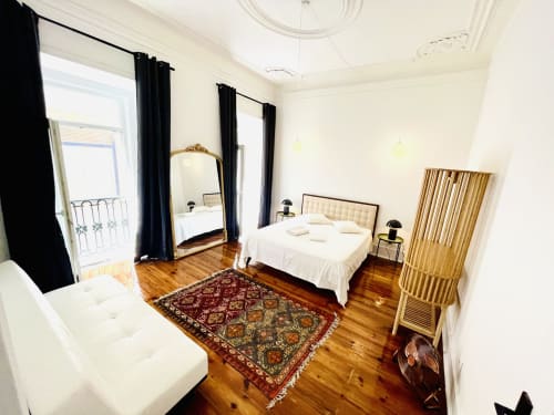 Spacious bedroom in Royal Prince Garden Apartments, Lisboa, featuring wooden floors, ornate mirror, and garden view balcony