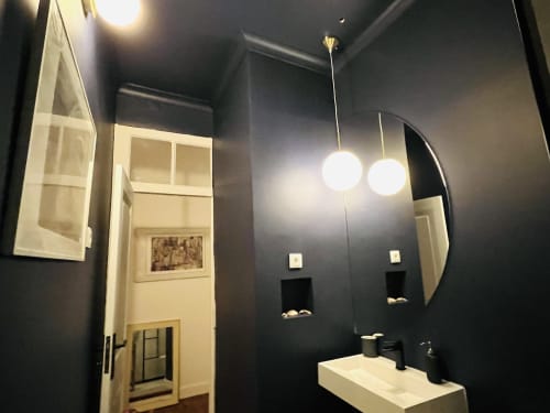 Modern bathroom in Royal Prince Garden Apartments, Lisboa, with dark walls, white sink, dual pendant lights, and illuminated