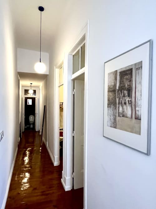 Modern hallway in Royal Prince Garden Apartments, Lisboa, with white walls, pendant lighting, and framed artwork