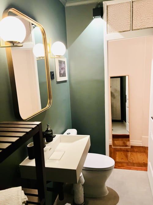 Modern bathroom in Royal Prince Garden Apartments, Lisboa with green walls, white sink, toilet, illuminated mirror, and