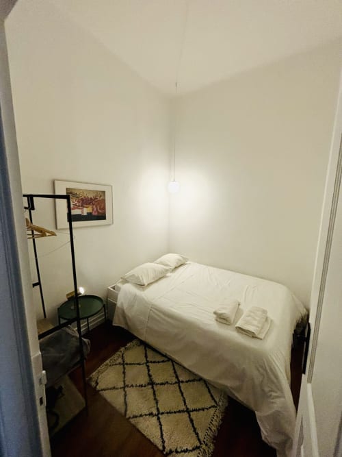 Cozy bedroom at Royal Prince Garden Apartments in Lisbon with white bedding, wooden floor, and minimalist décor
