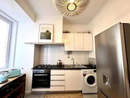 Modern kitchen in The River 3Bedroom Apartment at Royal Prince Garden Apartments, Lisboa, with white cabinets, black