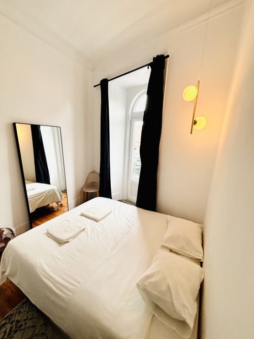 Bright bedroom at Royal Prince Garden Apartments, Lisboa, with white bed, black curtains, mirror, and modern lighting