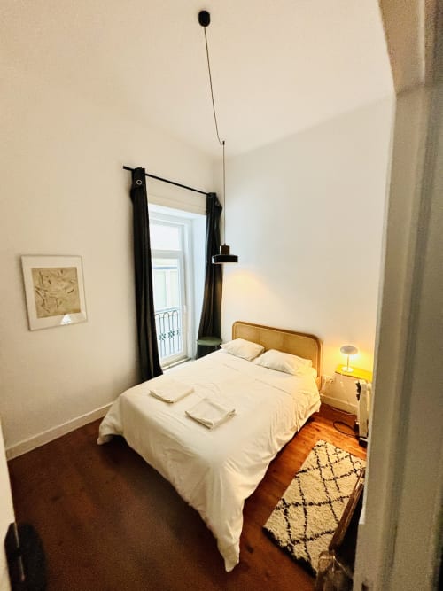 Cozy bedroom at Royal Prince Garden Apartments in Lisbon with queen bed, wooden flooring, and balcony access