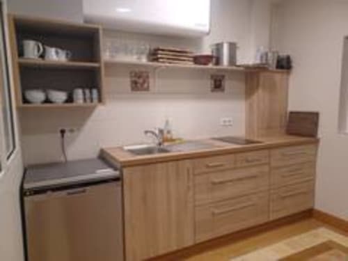 Cuisine moderne à la réception de l'hôtel Accolade à Châteaudun avec mobilier en bois et appareils en acier inoxydable