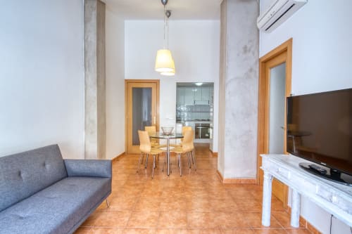 Moderno apartamento de planta abierta en Palafrugell con comedor, sala de estar, cocina y entretenimiento TV.