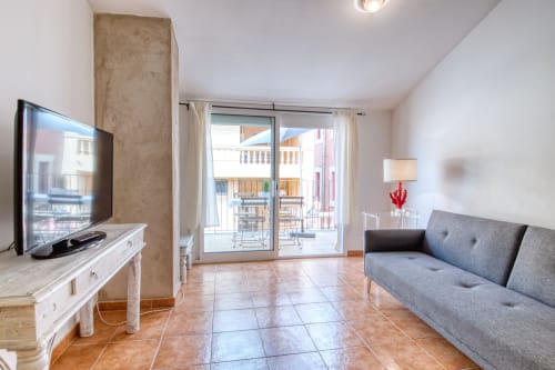 Salón moderno del apartamento Finques Garcia Enrich en Palafrugell con sofá, TV y acceso a terraza