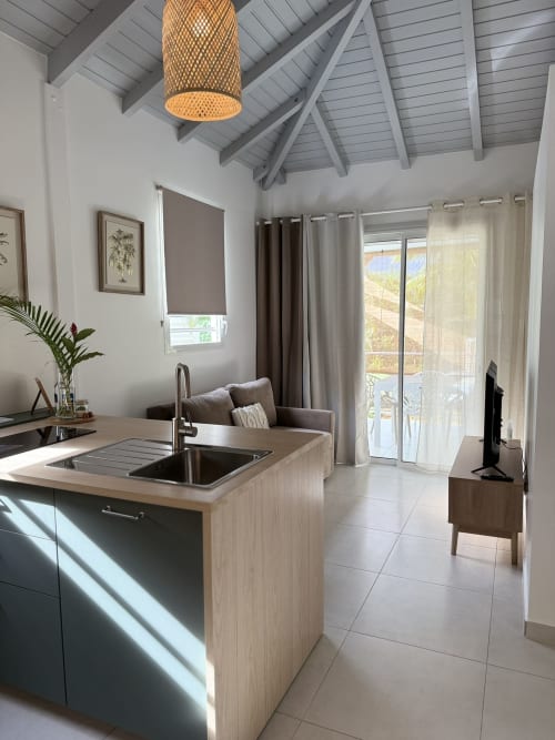 Cuisine moderne et séjour dans le Bungalow Ixora au Domaine de la Glacière, Petit-Bourg avec vue sur la piscine