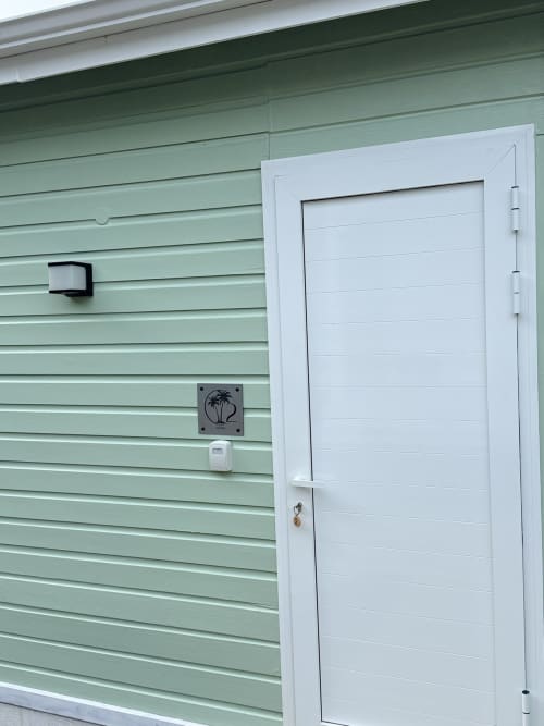 Entrée du bungalow Ixora au Domaine de la Glacière, Petit-Bourg avec bardage vert menthe et porte blanche