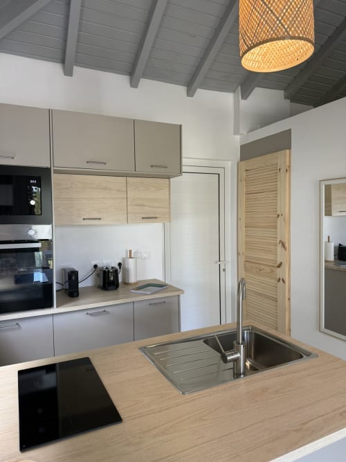 Cuisine moderne du bungalow Hibiscus au Domaine de la Glacière, Petit Bourg avec îlot en bois, évier inox et