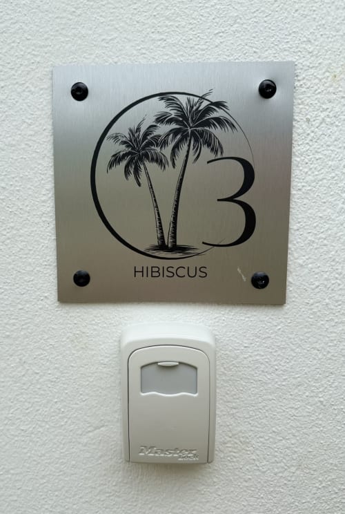 Panneau « Bungalow Hibiscus n°3 » avec illustration de palmier au Domaine de la Glacière, Petit-Bourg, Guadeloupe