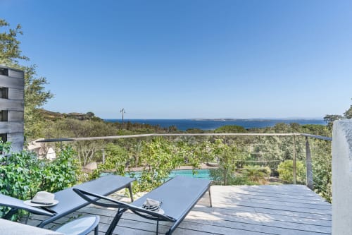Terrasse avec chaises longues donnant sur la piscine et la mer Méditerranée à la Villa Marina Di Cavu, Bonifacio