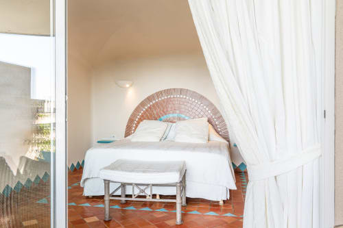 Chambre lumineuse avec tête de lit en briques voûtée, literie blanche, carrelage en terre cuite et vue sur mer à Villa Marina Di Cavu