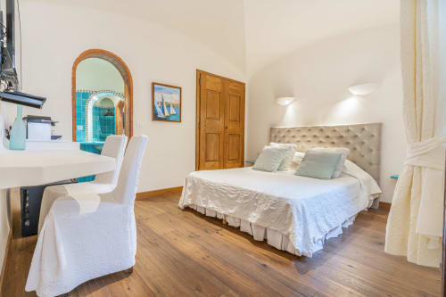 Chambre spacieuse avec vue sur le jardin à la Villa Marina Di Cavu à Bonifacio, lit, bureau, miroir arqué et parquets