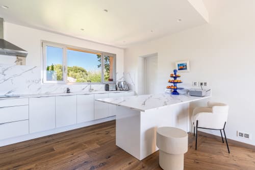 Cuisine moderne et luxueuse avec comptoirs en marbre blanc, parquets en bois et vue sur la mer à la Villa Marina Di Cavu, Bonifacio